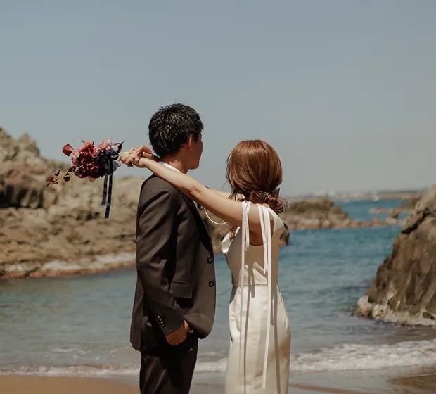 海辺に立つ新郎新婦